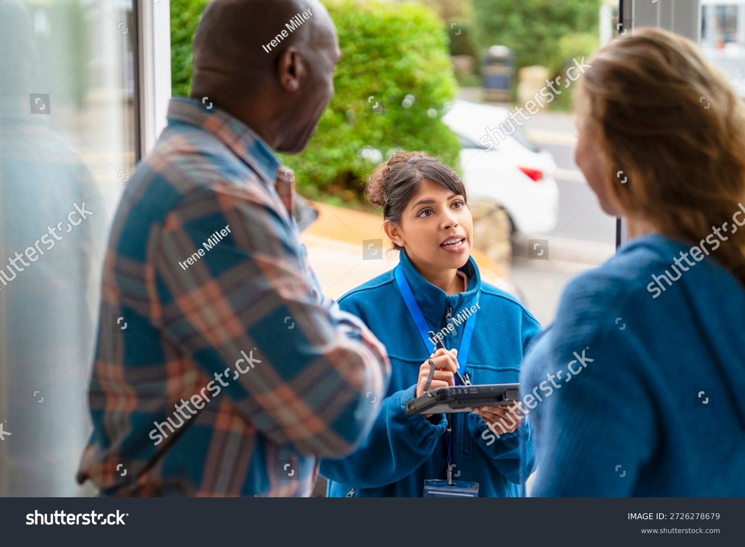 stock-photo-community-service-worker-interacts-with-two-residents-outside-a-building-during-the-day-2726278679